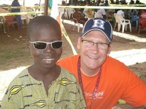 Optician and Pearle Vision Licensed Owner Gary Tonsager and a young participant of the Baseball in Benin program. Photo courtesy Baseball in Benin.
